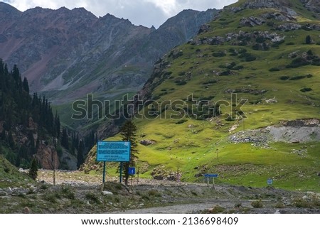 Beautiful mountains with rocky terrain and sky background. Barskoon river gorge. Road to Kumtor gold mine. Natural background. Travel, tourism in Kyrgyzstan concept.
