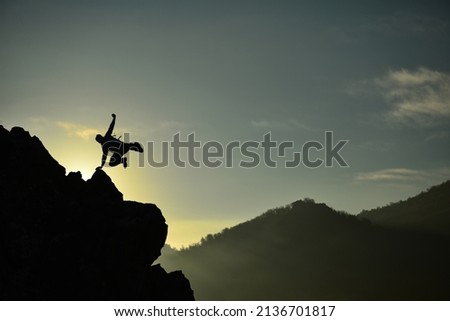 daring move and success of crazy mountaineer on cliff Royalty-Free Stock Photo #2136701817