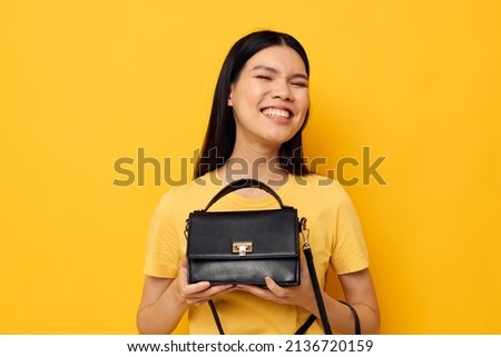 Portrait Asian beautiful young woman female clutch accessories posing yellow background unaltered
