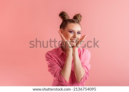 Funny girls with pigtails in pink shirt on pink background. Two bun hairstyle. Concept of naivety Royalty-Free Stock Photo #2136754095