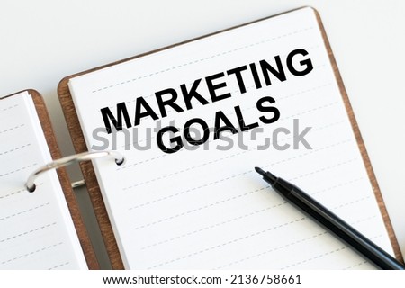 Marketing goals inscription on the notepad on the table next to the black marker