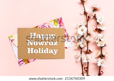 Sprigs of the apricot tree with flowers on pink background Text Happy Nowruz Holiday Concept of spring came Top view Flat lay Hello march, april, may, persian new year Greeting card