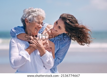 Taking time out to show some tenderness. Shot of a beautiful young woman and her senior mother on the beach. Royalty-Free Stock Photo #2136774667