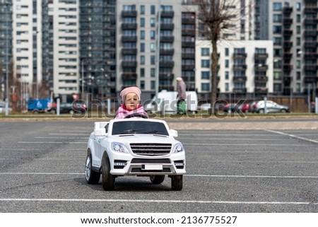 little girldriving a toy car. little driver, childrens car, concept of road safety, children in car