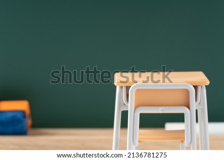 Miniature blackboard and school desk and chair.