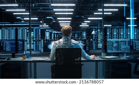 Back View of the Male Computer Engineer and Scientist Create Neural Network. In Office Displays Showing 3D Simulation of Big Data, Machine Learning Processes, Web3 Programming Concepts Royalty-Free Stock Photo #2136788057