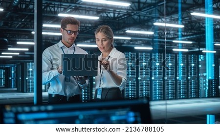 Male CEO Discusses Problem Solving with Female Partner in Office, They Brainstorming while Look on a Laptop. Smart Businesspeople Working in Finance. Specialists Work in Team Concept Royalty-Free Stock Photo #2136788105