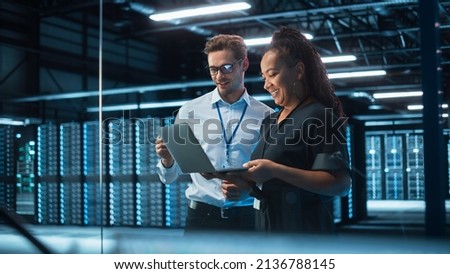 Senior CEO Talking to Young Confident Manager while Using Computer in Modern Office. Colleagues Discuss Commercial, Financial and Marketing Projects. Specialists Work in Diverse Team. Royalty-Free Stock Photo #2136788145