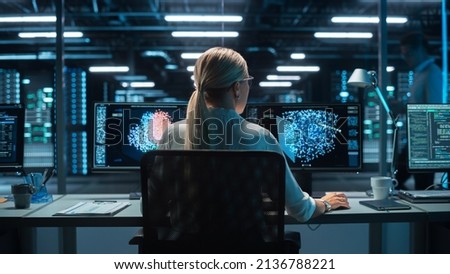 Futuristic Concept: Female Computer Engineer Looking on the Two Displays while Working on the Computer. Screen Shows Interactive Neural Network, Artificial Intelligence Project, User Interface Royalty-Free Stock Photo #2136788221
