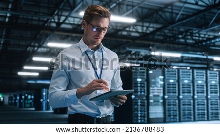 Late at Night in Private Office Businessman Looking Away while Works on a Laptop. Succesful Businessman and e-Business Entrepreneur Overlooking Server Farm Cloud Computing Facility Royalty-Free Stock Photo #2136788483