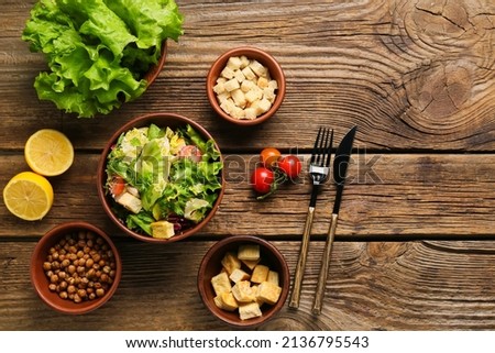 Composition with tasty vegan Caesar salad on wooden background Royalty-Free Stock Photo #2136795543
