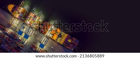 Aerial top view over international containers cargo ship at industrial import-export port prepare to load containers with big container loader ship vessel. global transportation and logistic business. Royalty-Free Stock Photo #2136805889