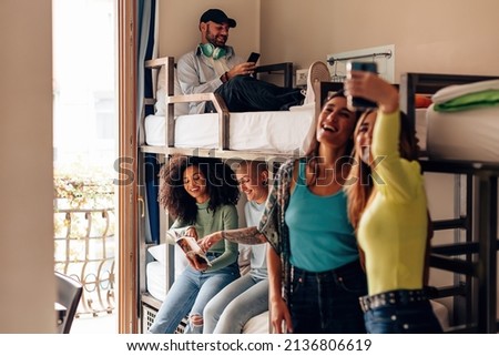 backpackers lifestyle in youth hostel - young people in room with bunk bed - travelers - students in the college dormitory Royalty-Free Stock Photo #2136806619