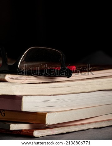 Old book with some dust particles on spectacles in black background
