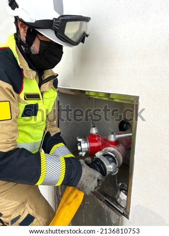 Firefighter places hose in dry column Royalty-Free Stock Photo #2136810753