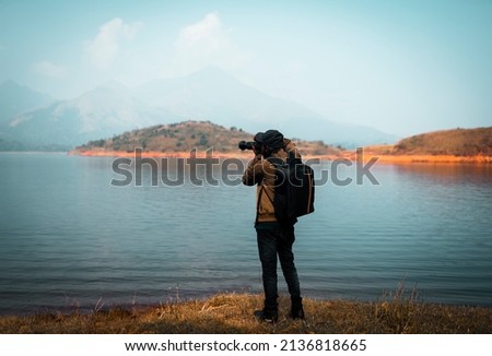 Man travel photographer with camera, Backpacker taking nature image, Nature Photography Day, camera day concept image