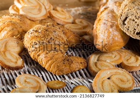 Assortment of fresh bread and bakery products lying on table .
