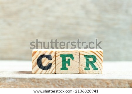 Alphabet letter block in word CFR (abbreviation Cost and freight) on wood background