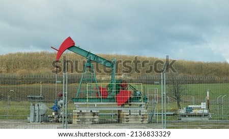Field fossil fuel pumpjack oil fracking crude extraction pump jack machine energy industry pumping unit equipment, refinery drilling mechanical machinery technology technical pipeline industrial Royalty-Free Stock Photo #2136833329
