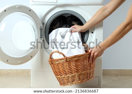 Concept of housework with washing machine against white wall Royalty-Free Stock Photo #2136836687
