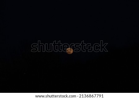 yellow moon against a blue sky