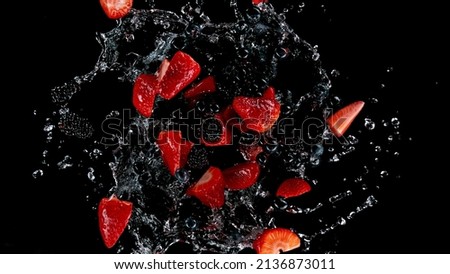 Freeze motion of berries in water splash. Isolated on Black Background. Royalty-Free Stock Photo #2136873011