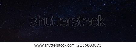 Panorama, blue night sky, milky way and stars on a dark background, universe filled with stars, nebula and galaxies with noise and photo pigmentation by long exposure and white balance.