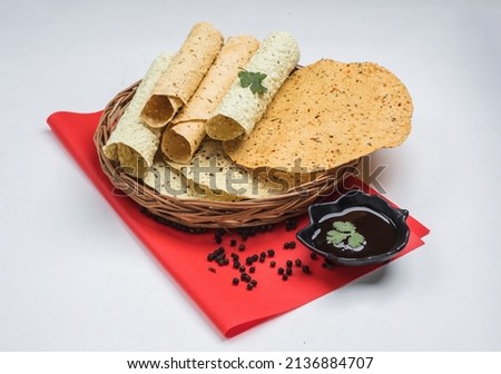 Papad, Roasted roll papad is an Indian traditional started food, served with Urad dal or black pepp er in red bowl, Colour Background, Urad Dal Papad, Papadum, Gujarati Papad
