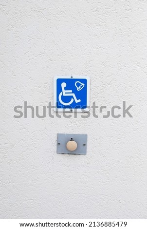 a button on the wall of a building for the disabled
