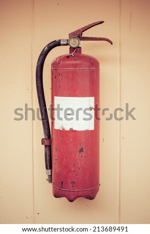 Old fire extinguisher tank on grunge wall process color