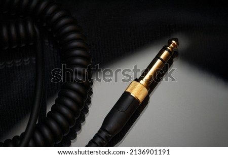 Gold-plated TRS connector for the analog audio signal are placed against a black background. Professional jack connector for sound equipment. Audiophile technologies concept.