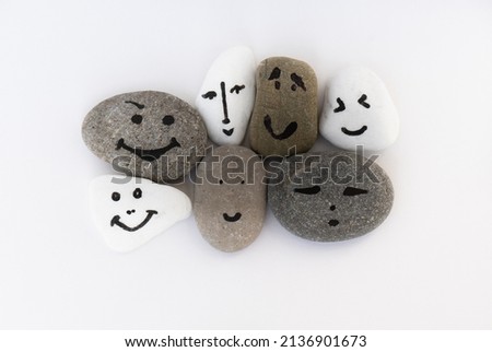 Solidarity and Tolerance. Faces painted on various stones. Different faces, different emotions. International tolerance and emotional intelligence. Joint action and existence. One team called humanity