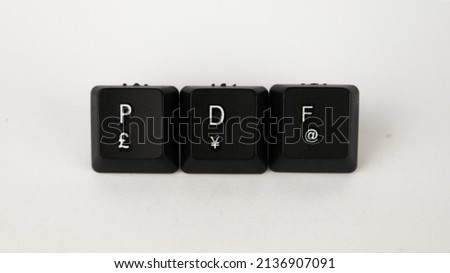 PDF text created with keyboard keys isolated on white background, computer terminology, white PDF on black keyboard, top view
