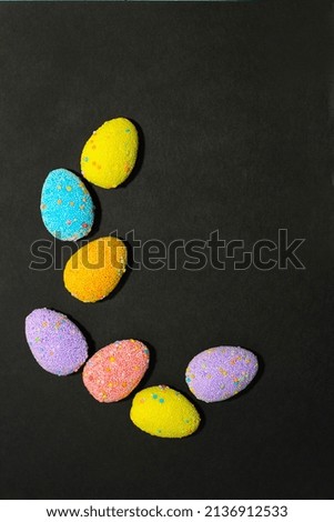 Multi-colored Easter decorative eggs on a black background.
