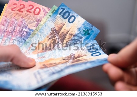 Close up of the man counting swiss francs Royalty-Free Stock Photo #2136915953
