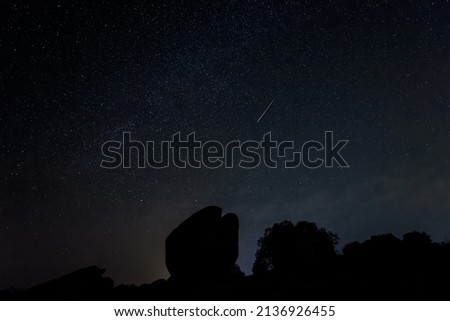 Night landscape with Perseid meteor in Barruecos. Spain.