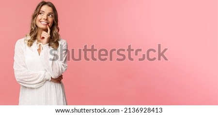 Beauty, fashion and women concept. Portrait of feminine, beautiful blond girl in white dress, imaging something romantic and interesting, smiling look up thoughtful, have plan, make decision