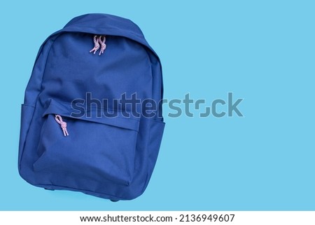 Blue backpack on blue background. Copy space