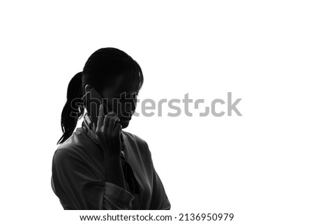 Silhouette of Asian woman calling with a smart phone. Royalty-Free Stock Photo #2136950979