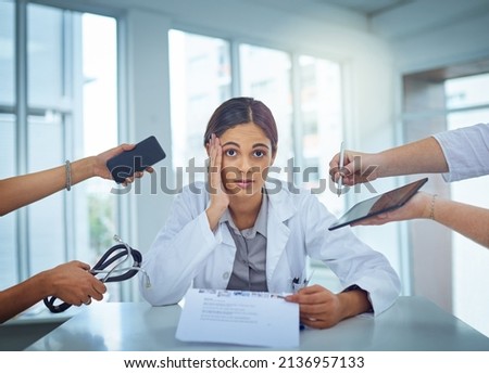 Its too chaotic to cope. Portrait of a young female doctor looking stressed out in a demanding work environment. Royalty-Free Stock Photo #2136957133