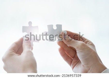 If the challenge exists so must the solution. Cropped shot a businessman holding two puzzle pices. Royalty-Free Stock Photo #2136957339