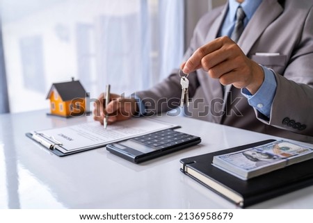 Real estate company to buy houses and land are delivering keys and houses to customers after agreeing to make a home purchase agreement and make a loan agreement. Discussion with a real estate agent