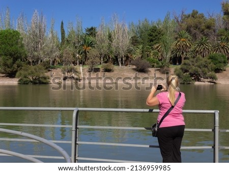 Blonde woman taking a picture.