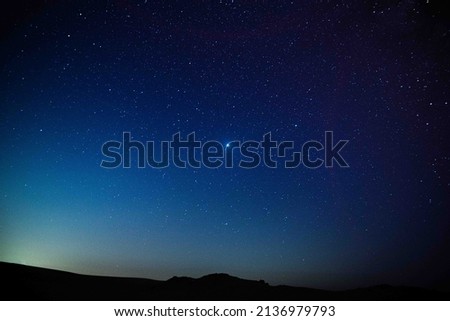 Astro photography in a desert nightscape with milky way galaxy. The background is stary celestial bodies in astronomy.
