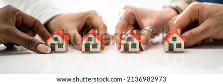 Homeowner Association By People Holding House Model On White Surface Royalty-Free Stock Photo #2136982973