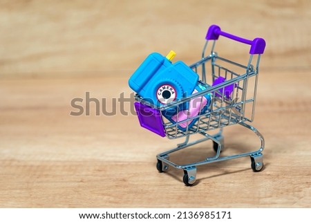 Camera in a basket, cart. The concept of price, purchase of photographic equipment.