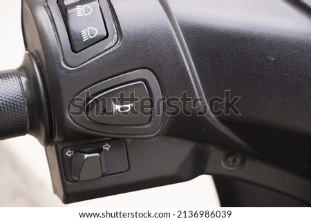 Close-up view of horn button, turn signals, and lamp on left Matic motorcycle handlebar

