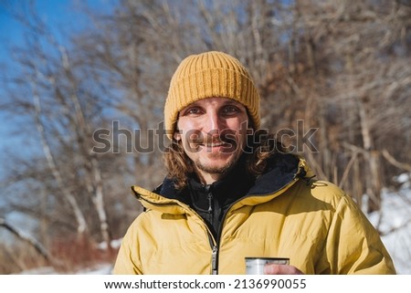 A smile on the young guy's face. A man in yellow clothes, a tourist in a hat in nature, a hipster laughing at the forest behind his back,. High quality photo