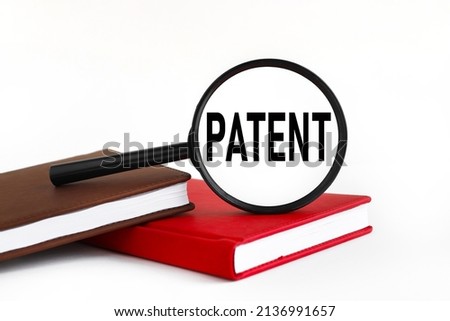 Patent. text on magnifier glass on white background. on a red and brown background
