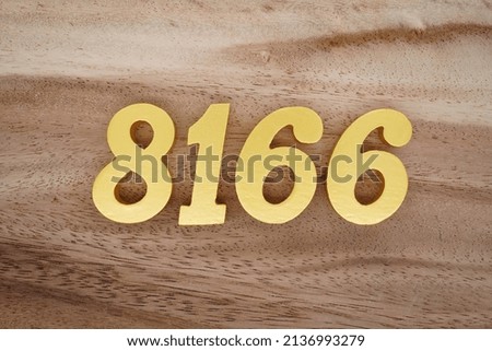 Wooden  numerals 8166 painted in gold on a dark brown and white patterned plank background.